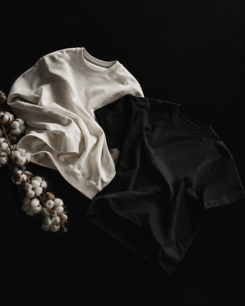 Ivory crew and black tee laid with a cotton branch